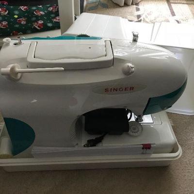 Singer sewing machine with hard sided carrying case.
