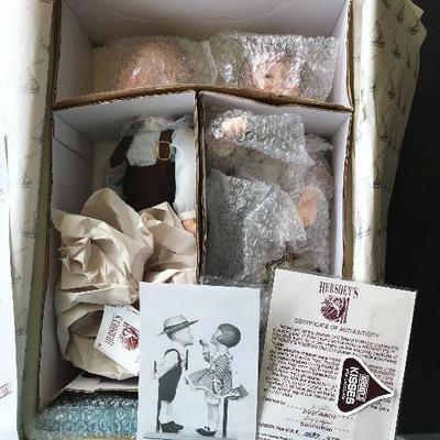 Hershey Chocolate Boy and Girl Kissing set.  Comes with a low certificate number.  Includes 2 dolls, stand, and protective covering.