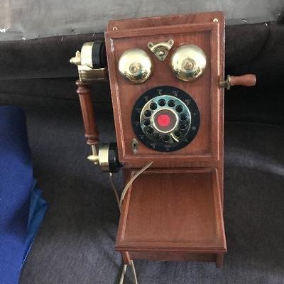 Button dial wall phone made to look like old fashion rotary with storage in bottom.