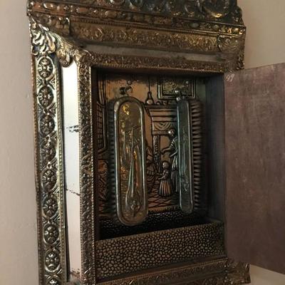 Decorative tin and wood mirror with shoe brushes inside. $100