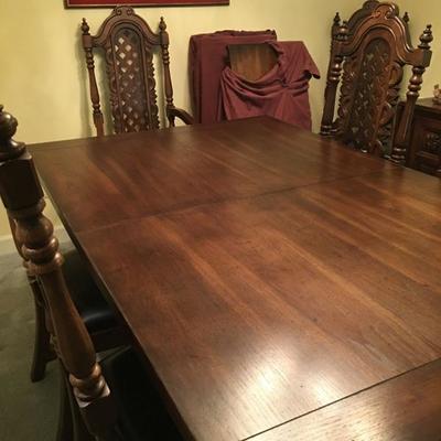 Solid ornate pecan wood dining table w/10 chairs and 3 leaves.