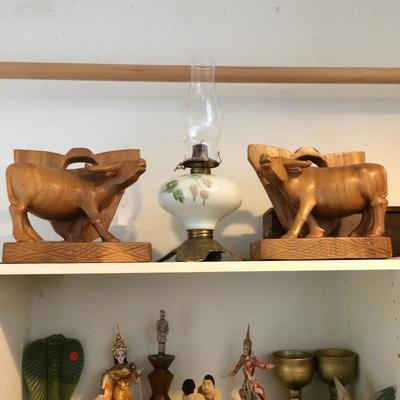 Large hand carved water buffalo book ends and an antique oil lamp.