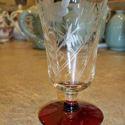We have a set of 8 Depression glass etched sherry glasses with red bases.
