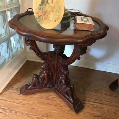 Antique Glass Top with Naked Women carved on the base supporting the table.  Price $ 50