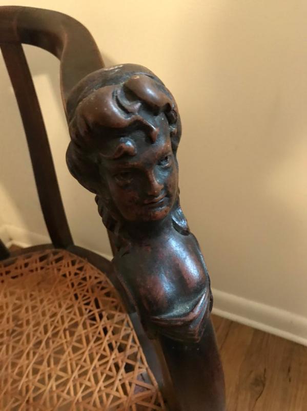 Closeup of the Woman bust carved into these wood chairs. 