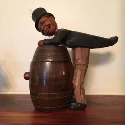 Black Americana man in tails opens barrel - cigarette box?