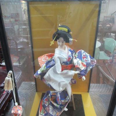 Oriental doll in display case