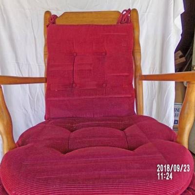 wooden rocker with red cushions