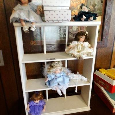 Small wooden shelf with 5 porcelian dolls.