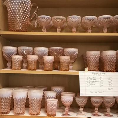 Multiple sizes of pink Opalescent Hobnail glasses and stems and pitcher
