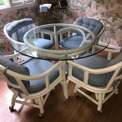 Glass top rattan dining table and 4 swivel chairs