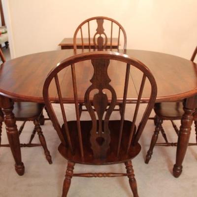 #606  All wood dining farmhouse table with 4 chairs and 1 -18"leaf  Damage to table from plug in leak
66"L x 48"W x...