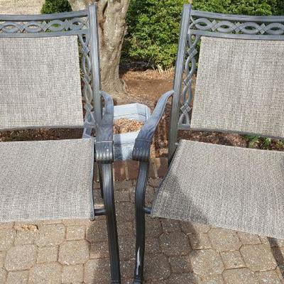 pair of outdoor chairs mesh bottom and top with wrought iron filegree