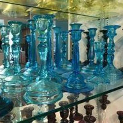 Lots of colored glass candlestick holders. Depression era.