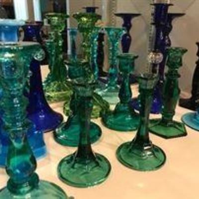 Lots of colored glass candlestick holders. Depression era.