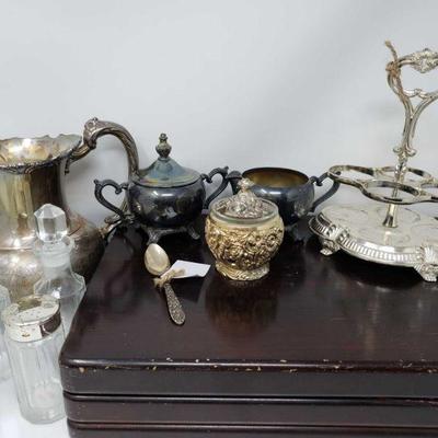 #600: Assorted Silver Plated Pieces and Glassware
Pitcher, flatware, cream and sugar set, small decaters, salt and pepper shaker