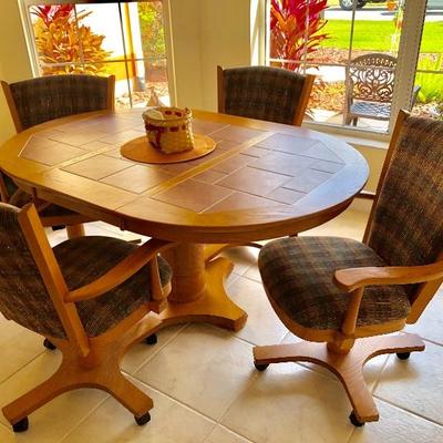 Oval Wood Pedestal Tile Top Dinette Set with One Leaf and Four Upholstered Chairs on Wheels  (Table 42"W  61"L  30"H)...