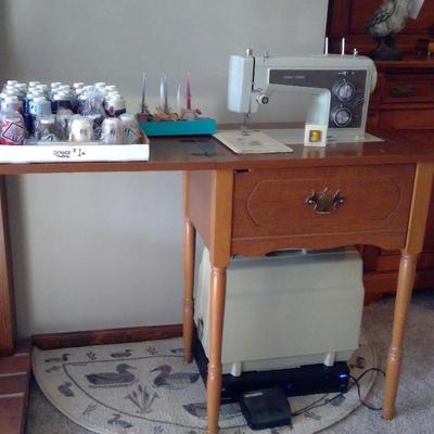 Kenmore metal zigzag sewing machine in cabinet and with portable case.