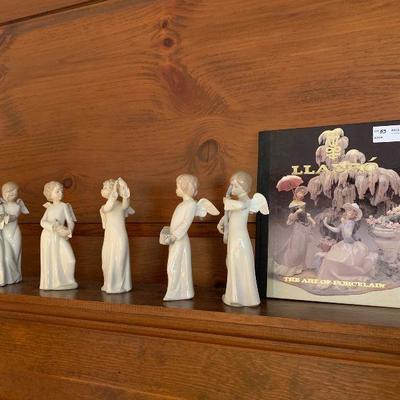 Five LLadro angel figures together with a book  