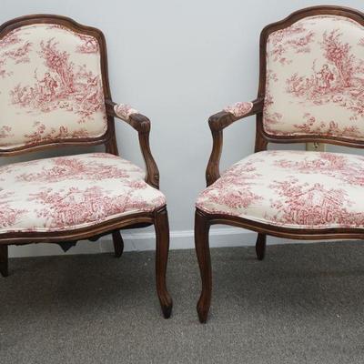 A pair of 20th c. French style red and white toile fabric fauteuil chairs. The upholstered back is framed by rounded curved wood back....