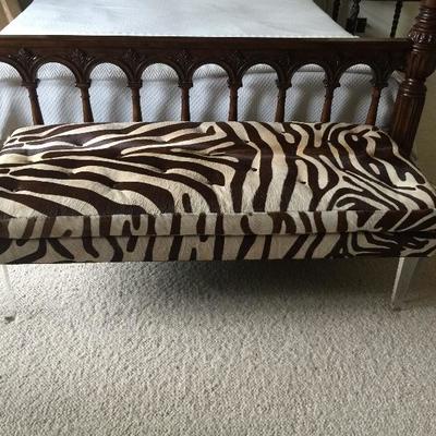 Bench made of zebra hide with lucite legs