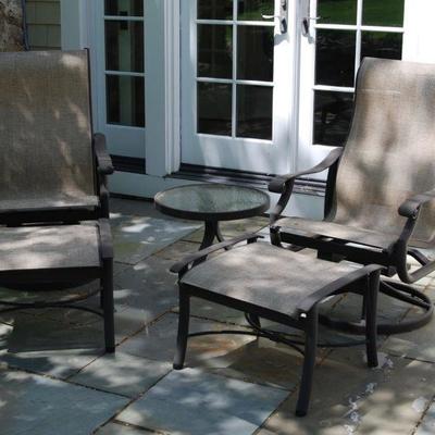 Pair of swivel chairs with ottomans