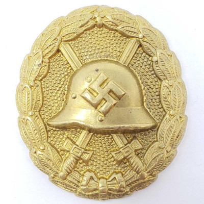 2076: 	
German World War II Gold Spanish Condor Legion Wound Badge
The front showsa German helmet in the center with a pair of crossed...