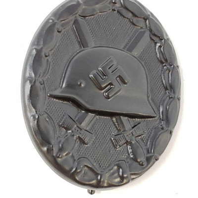 2042: 	
German World War II Black Wound Badge
The front shows a German helmet in the center with a pair of crossed swords in the back...