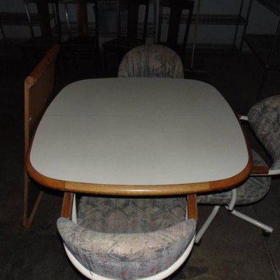 Nice kitchen table has leaf with 3 roller chairs
