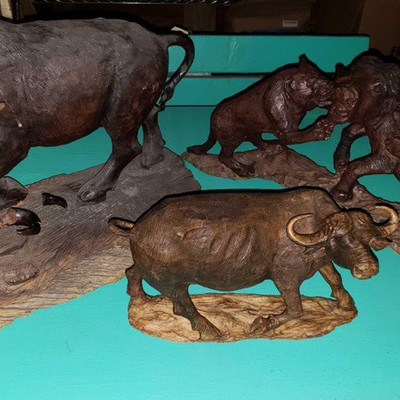 605: 	
Three hand carved wooden African water buffalo statues
Shown here are three elaborately detailed, carved wooden figures, all are...