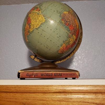 Reploge globe on stand holding world atlas