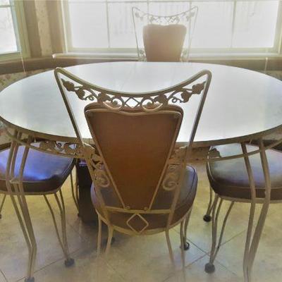 MCM round white laminate kitchen table with 2 leaves.  (round when leaves are out).  Wrought iron legs, and  matching wrought iron...