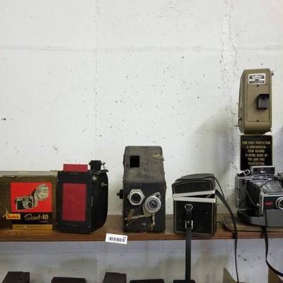 Top center shelf of 5 old cameras- Kodak, Polaroid ...