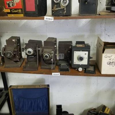 Bottom wood shelf of 5 old cameras- Graflex photor ...