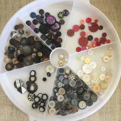 Large assortment of buttons and container