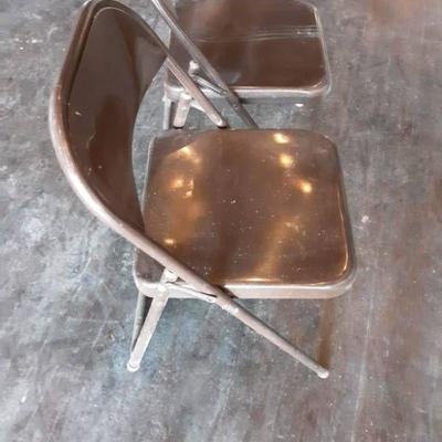 (2) Brown Metal Folding Chairs.