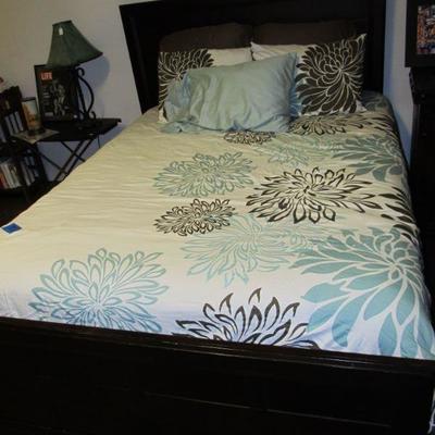 Designer bedding and a modern styled bed that can be a full-size or a queen.