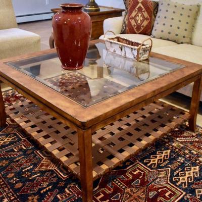 Glass top coffee table with woven leather lower shelf