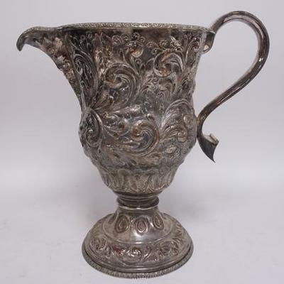 1188	LARGE ORNATE SILVER ON COPPER PITCHER, SOME WEAR TO THE SILVER PLATE HAS A FACE UNDER THE SPOUT, 17 1/2 IN H 
