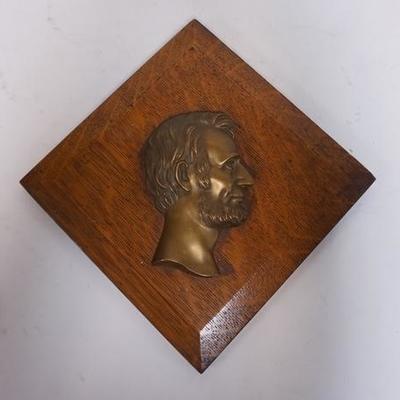 1113	METAL PROFILE BUST OF ABE LINCOLN MOUNTED ON A BEVELED OAK PLAQUE, 10 3/4 IN X 10 1/2 IN 
