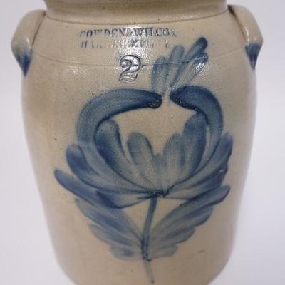 1007	COWDEN AND WILCOX BLUE DECORATED 2 GALLON STONEWARE CROCK WITH A LARGE FLOWER. 11 1/2 IN H
