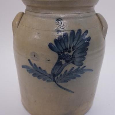 1004	2 GAL BLUE DECORATED STONEWARE CROCK. ROUGHNESS ON THE HANDLES. FLAT FLAKE INNER TOP RIM 11 1/2 IN H
