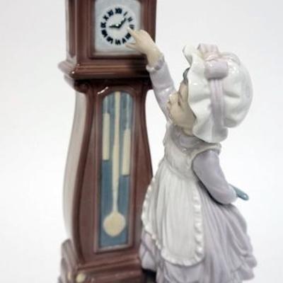 1007	LLADRO FIGURE OF A GIRL STANDING ON A STOOL SETTING A TALL CASE CLOCK WITH A CAT SITTING ATOP. 11 IN H
