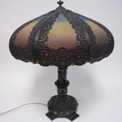 1039	REVERSE PAINTED TABLE LAMP W/ ORNATE METAL OVERLAY, HAS A FIGURAL BASE W/ PUTI, 24 1/2 IN H, SHADE APP 19 IN D 
