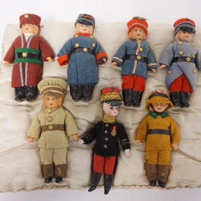 1020	LOT OF 7 ANTIQUE MINIATURE DOLLS DRESSED IN UNIFORMS, ATTACHED TO BLANKET. 6 ARE CELLULOID, 1 BISQUE. MEASURING 4 TO 5 IN HIGH