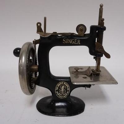 1034	ANTIQUE CHILDS SINGER CAST IRON MINIATURE SEWING MACHINE. 7 1/4 IN HIGH X 7 IN WIDE