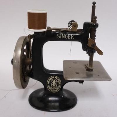 1032	ANTIQUE CHILDS SINGER CAST IRON MINIATURE SEWING MACHINE. 7 1/4 IN HIGH X 7 IN WIDE