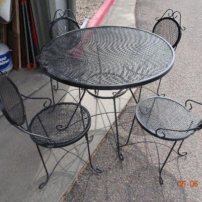 WROUGHT IRON TABLE AND 4 CHAIRS.