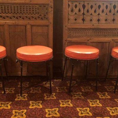 4 Vintage Ottoman/Stools. Faux  orange leather and wrought iron style legs. Priced separately.