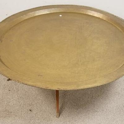 1255	LARGE ENGRAVED BRASS TRAY TABLE, W/ FOLDING WOODEN BASE, 47 1/2 IN DIAMETER 
